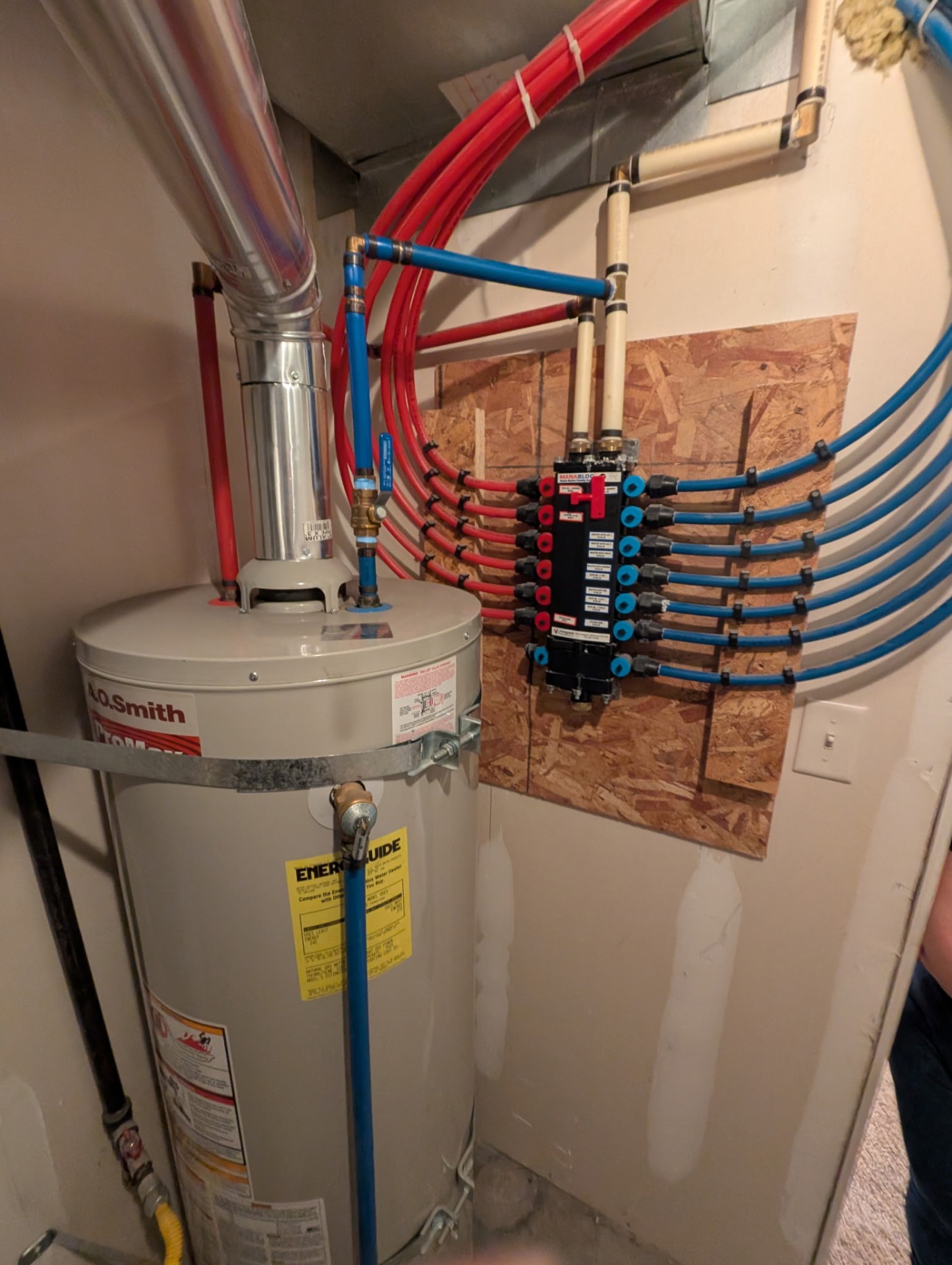 PEX manifold rebuild in an American Fork basement, with red and blue PEX supply lines fanning out across the wall